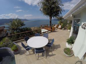 a table and chairs on a patio with a view of the water at Casa ilhabela in Ilhabela