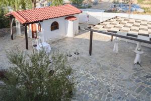 a pavilion with a table and chairs in front of a building at Matina Pefkos Aparthotel in Pefki