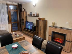 a living room with a table and a fireplace at Borovets Sequoia2 luxury Apartment in Borovets