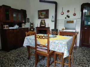 a dining room with a table and chairs and a kitchen at Casa le Rose in Ameno
