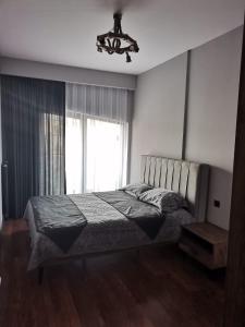 una camera da letto con un letto con un lampadario a braccio e una finestra di BENESTA BEYOGLU a Istanbul
