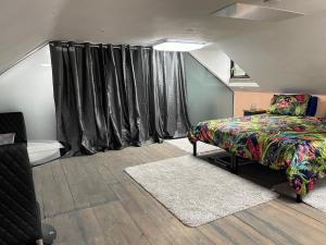 a bedroom with a bed and black curtains at Robinas Cotswold Coach House in Witney