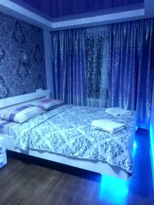 ザポリージャにあるApartment 2Bed Rooms Lux on Gagarina Prospect Soborniyのベッドルーム(青いカーテン付きの白いベッド1台付)