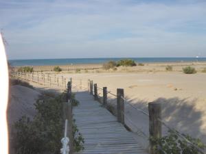 a wooden boardwalk leading to a beach with the ocean at Allotjament Joana in Riumar