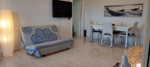 ein Wohnzimmer mit einem Stuhl, einem Tisch und einem TV in der Unterkunft Sweet house in Bari
