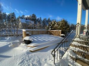 a snow covered yard with stairs and a house at Villa Movägen Family friendly Free Wifi Lake nearby in Mörlunda