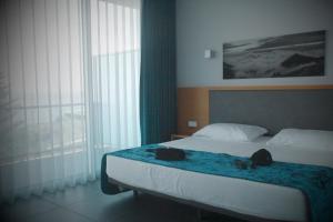 Un dormitorio con una cama con dos bolsas. en Whalesbay Hotel Apartamentos en Capelas