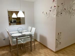 ein Esszimmer mit einem Tisch und weißen Stühlen in der Unterkunft Apartamentos Alcañiz, Ana in Alcañiz