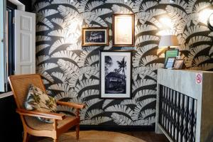 - un couloir avec un mur recouvert de papier peint à feuilles de palmier dans l'établissement Check-Inn at Little India, à Singapour