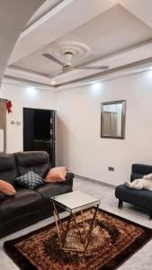 sala de estar con sofá y mesa en Janesis Holiday Homes, en Oyibi