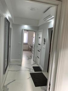 una camera con corridoio, pareti bianche e pavimenti piastrellati bianchi di Centru Vechi Apartament a Suceava