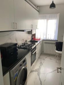 una cucina bianca con piano cottura e lavandino di Centru Vechi Apartament a Suceava