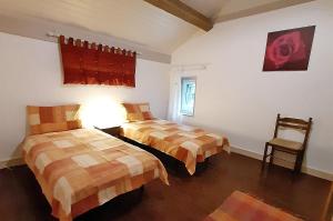 una habitación de hotel con dos camas y una silla en Le Seigneur des Bois, en Bussière-Galant