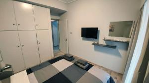 a room with a bed and a tv on a wall at METROPOLITAN MACVIEW-4 ΔΙΑΜΕΡΙΣΜΑ in Piraeus