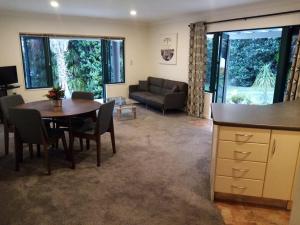 a living room with a table and a couch at Gulf Harbour Guest House Apartment in Auckland