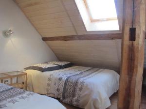 um quarto no sótão com 2 camas e uma janela em La Fruitière - Gîte d'étape et de séjour em Arvieux