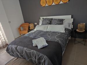 a bedroom with a bed with a black and gray comforter at Casa Montegama in San Nicolás del Puerto +38 photos
