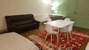 sala de estar con mesa, sillas y sofá en Grand studio et jolies chambres à louer, en Passins