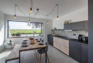 a kitchen with a wooden table and a dining room at Villa veld en velo in Bree