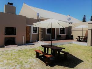 a picnic table and a bench with an umbrella at Proleefic House on Florence in Bellville