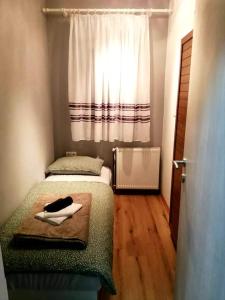 a small bedroom with two beds and a window at Apartman Goldy in Zagreb