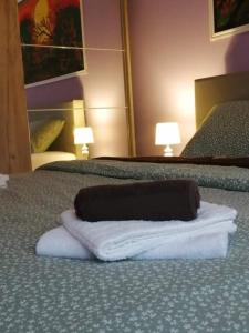 a towel laying on a bed in a hotel room at Apartman Goldy in Zagreb