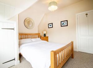 a bedroom with a large bed and a mirror at Kerns Cottage Stratford-upon-Avon in Stratford-upon-Avon