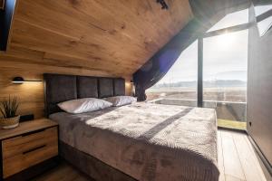 sypialnia z łóżkiem i dużym oknem w obiekcie Domki W Karkonoszach Szmaragdowy Widok w mieście Wojcieszyce