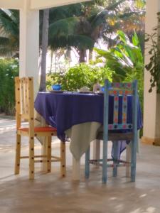 a table with a blue table cloth and two chairs at Vila Saguaro in Trairi