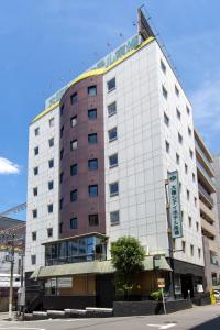 Osaka City Hotel Kyobashi في أوساكا: مبنى ابيض كبير على زاوية شارع