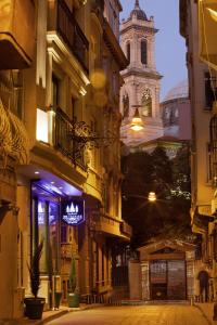 uma rua da cidade à noite com uma torre do relógio em The Trinity Hotel Taksim - Special Category em Istambul