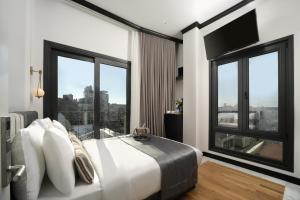 a bedroom with a large white bed with a large window at The Trinity Hotel Taksim - Special Category in Istanbul