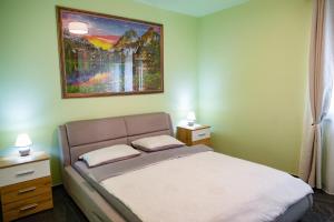 a bedroom with a bed and a painting on the wall at BIO Residence Apartments Timisoara in Dumbrăviţa