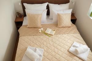 a bedroom with a bed with a book and flowers on it at MIR i LIRA apartmani Kopaonik in Kopaonik +84 photos