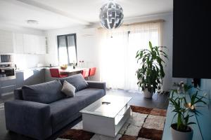 a living room with a couch and a table at BIO Residence Apartments Timisoara in Dumbrăviţa