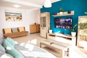 BIO Residence Apartments Timisoara في Uisenteş: غرفة معيشة مع أريكة وتلفزيون