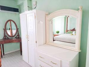 a bedroom with a white dresser and a mirror at Belle View Apartment Villa - Cactus in Laborie