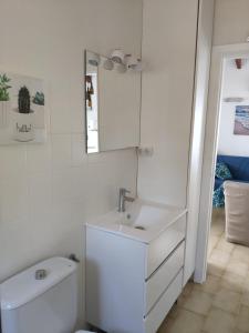 Baño blanco con lavabo y aseo en Villa Las Ardillas, en Calpe