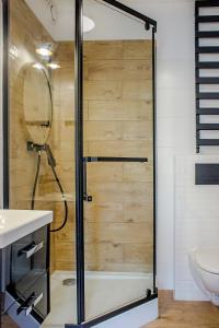 W łazience znajduje się prysznic ze szklanymi drzwiami. w obiekcie Pod Słoneczną w Szczawnie Zdroju