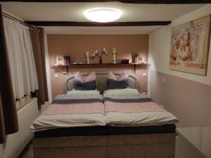 a bedroom with a bed with two pillows at FeWo Am alten Holzplatz in Drübeck