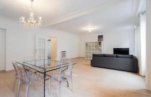 een eetkamer met een glazen tafel en een bank bij BIG WHITE in Nice +5 foto's