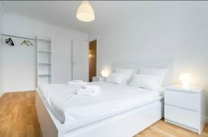 een witte slaapkamer met een groot wit bed met witte kussens bij BIG WHITE in Nice