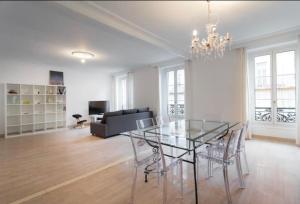 een eetkamer met een glazen tafel en stoelen bij BIG WHITE in Nice