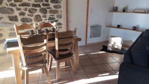 a table and chairs in a room with a stone wall at Le Cocon Ardéchois in Saint Martin sur Lavezon +6 photos