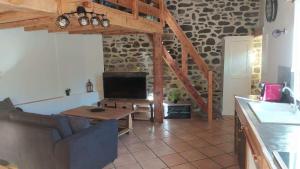 a living room with a table and a tv in a building at Le Cocon Ardéchois in Saint Martin sur Lavezon