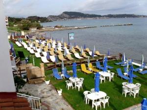 una fila di sedie, tavoli, sedie e acqua di Seashell Studios ad Argásion