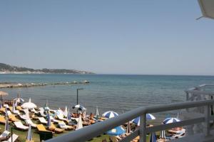 a bunch of chairs and umbrellas on a beach at Seashell Studios in Argasi