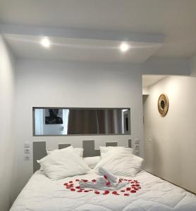 Un letto bianco con un mazzo di rose rosse sopra di Lady laying a Le Diamant