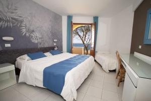 a bedroom with a large bed and a window at Perla Del Golfo Resort in Terrasini