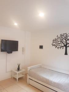 a bedroom with a bed and a tree on the wall at PASAJE EN EL CENTRO DE LOMAS in Lomas de Zamora